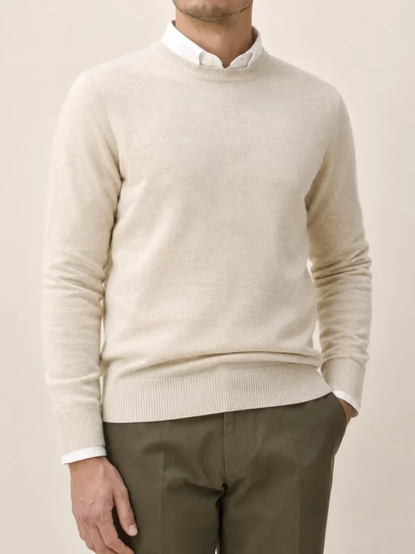 Jersey de cuello redondo de lana merina crudo sobre camisa blanca