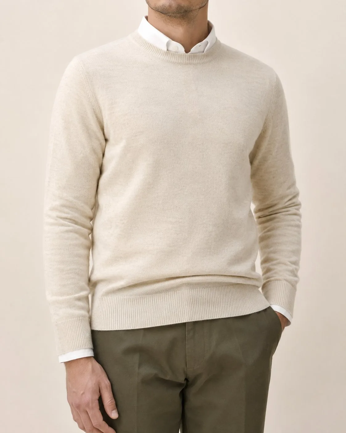 Jersey de cuello redondo de lana merina crudo sobre camisa blanca